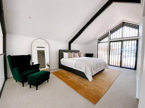 邓斯伯勒Le Soleil new villa, golf & heated pool的一间卧室配有一张大床和一张绿色椅子