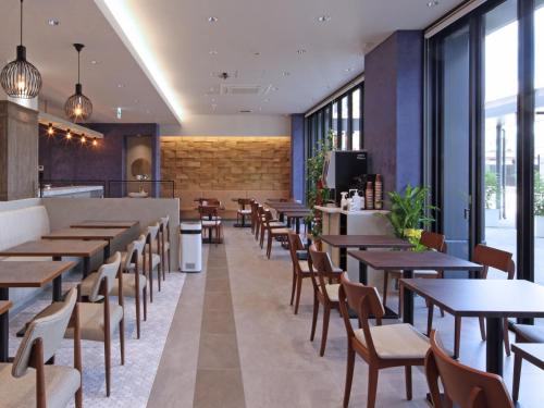 敦贺市Hotel Granbinario Tsuruga的餐厅设有桌椅和窗户。