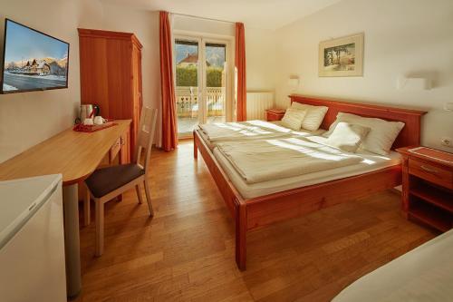 克拉尼斯卡戈拉Rute Hotel and Apartments的一间卧室配有一张大床、一张桌子和一张书桌