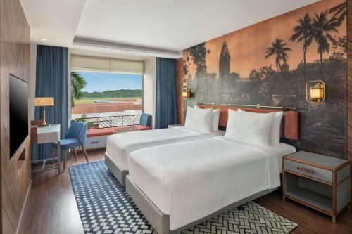 钦奈Radisson Blu Hotel GRT, Chennai International Airport的酒店客房设有两张床和一个阳台。