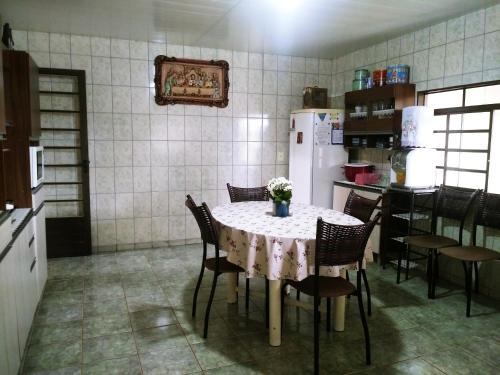 圣罗克迪米纳斯Aluguel para Temporada的厨房配有桌椅和冰箱。