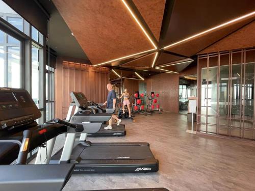 芭堤雅市中心EDGE Central Pattaya的健身房,里面设有一排跑步机和机器上的人
