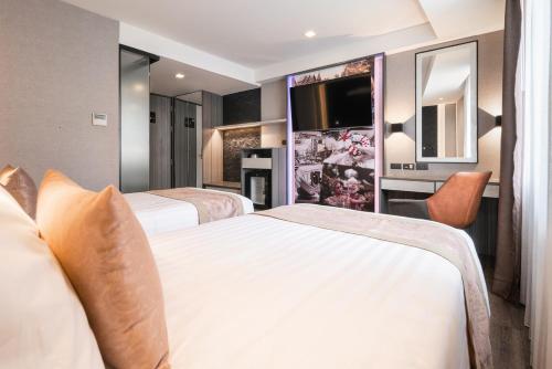 曼谷Aspira Gems Center Silom的酒店客房设有两张床和一台平面电视。