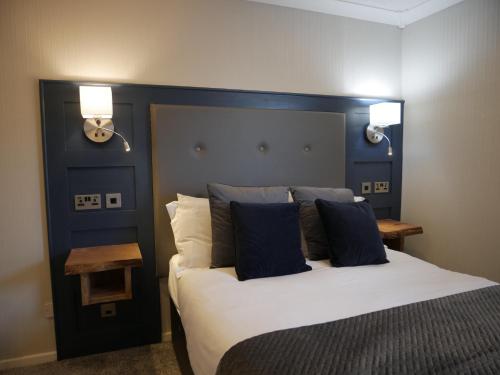 纽卡斯尔Harbour House Inn Newcastle, Northern Ireland的一间卧室配有一张大床和蓝色床头板