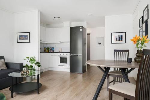 RåholtModerne leilighet - nært flyplass - lader for elbil的厨房以及带桌子和冰箱的客厅。