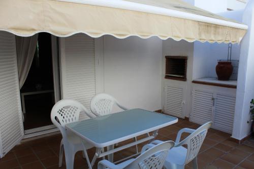 加的斯La Casita de Marina Golf-Costa Ballena的阳台配有蓝色的桌椅、桌子和椅子