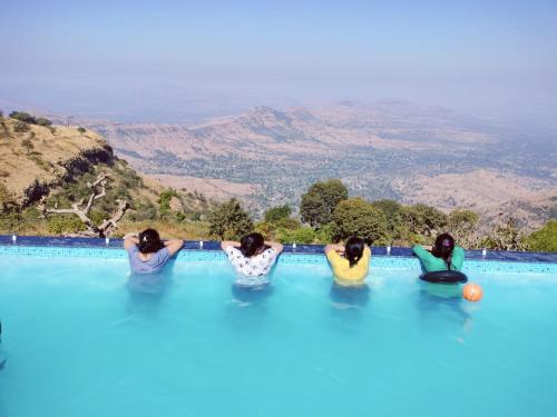 瓦伊Hilltop Resort and Agro Tourism Wai, Near Panchgani的一群三个女孩坐在游泳池里