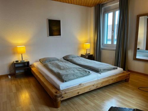 阿尔邦Charmante und zentrale Wohnung am Weiherpark Arbon的一间卧室配有一张床,两台桌子上放着两盏灯