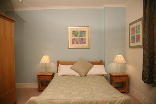 布罗姆利娱乐节目酒店的一间卧室配有一张床、两个床头柜和两盏灯。
