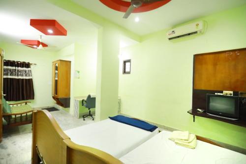 TripunnittaraArackal Tourist Home的一间医院间,配有床和电视