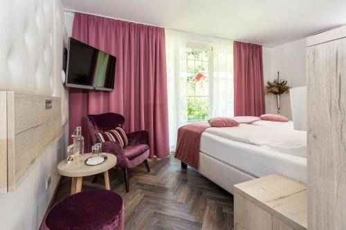 DafinsBoutiquehotel Bergvilla的一间酒店客房,设有两张床和电视