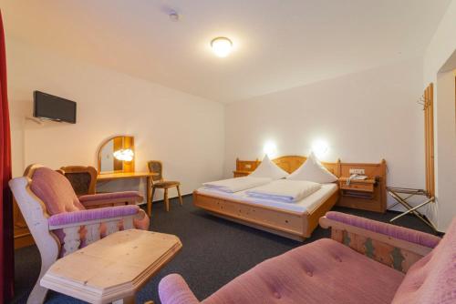 俄伦比斯费佛达尔旅馆酒店的酒店客房,配有一张床和两把椅子