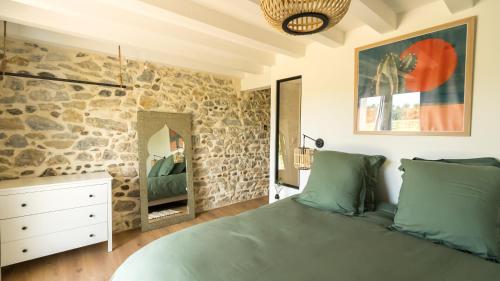 圣茹尔德马朗讷Le Ranch Kabahina Golf的一间卧室设有石墙和一张床