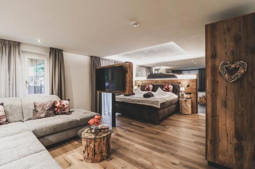 摩梭佩尔德罗霍夫阿尔卑斯生活方式酒店的客厅配有沙发和1张床