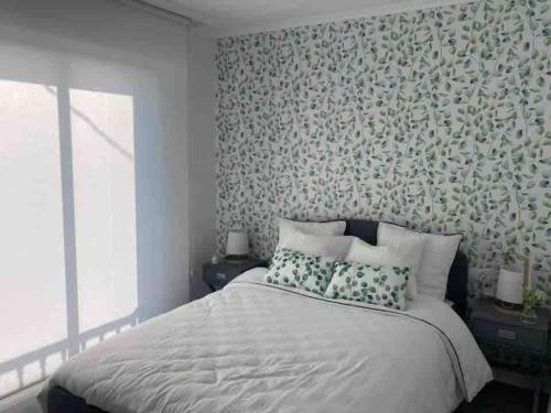 奥伦塞Casa dos Alén的一间卧室配有一张带花卉壁纸的床