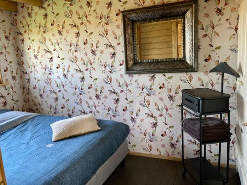 OpperdoesLandelijk gelegen houten huisje的卧室配有一张床,墙上设有镜子