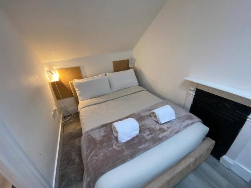 伦敦Cosy flat in London的小房间设有一张带两个白色枕头的床