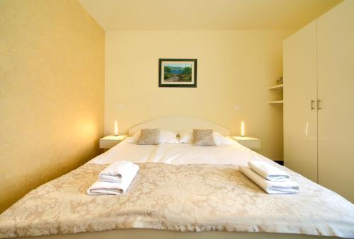 科尔尼奇Apartments ROYAL的一间卧室配有一张床,上面有两条毛巾