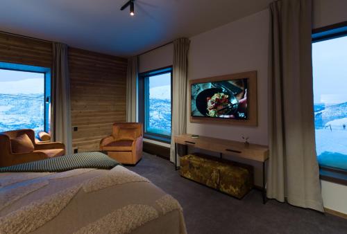 海姆瑟达尔Skarsnuten Mountain Resort & SPA的一间卧室配有一张床和一台电视,部分设有窗户。