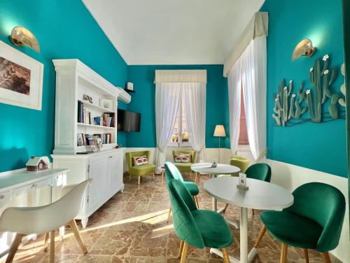 锡拉库扎珀斯塔酒店的客厅拥有蓝色的墙壁和桌椅