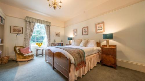 GilwernPantybeiliau House Bed & Breakfast的卧室配有床、椅子和窗户。