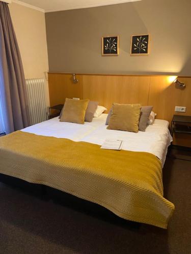 海尔翠森海特安克尔酒店的一间卧室配有一张带黄色毯子的大床