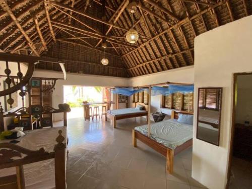 Ushongo MabaoniBaobab Beach Villa, Ushongo Beach, Pangani的一间带两张床的卧室和一间客厅