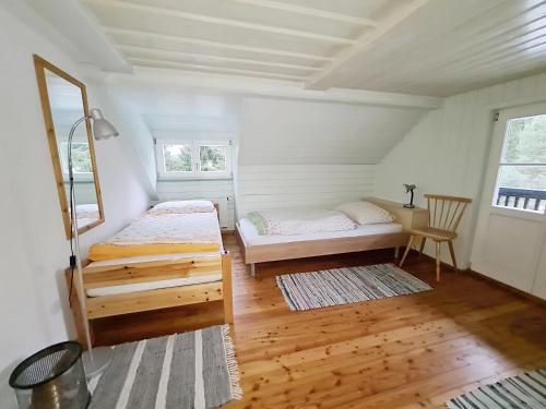 VölleggHaus Völlegg的一间铺有木地板的客房内配有两张床的卧室