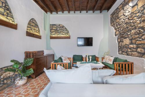 帕斯蒂达Philoxenia traditional house的客厅配有白色家具和石墙