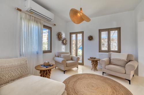 安倍拉斯Amalgam Homes Paros的客厅配有白色家具和窗户。