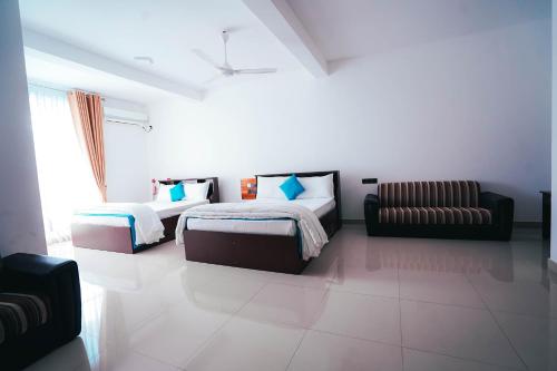 卡尔库达Sun Ray Rest House的一间带两张床和一张沙发的卧室
