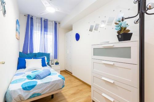 马德里Apartamento Puente de Segovia的小卧室配有带蓝色枕头的床