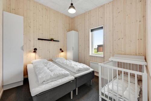 森讷维Lalandia Søndervig的一间卧室配有一张床和一张婴儿床
