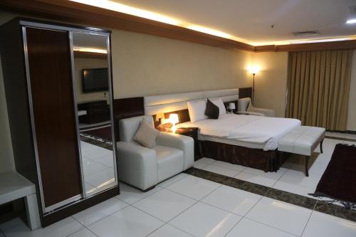 The Burj Ghazanfar in Mazar-e Sharif的配有一张床和一把椅子的酒店客房