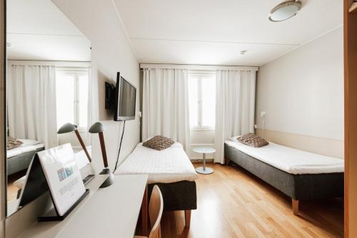 科特卡Hotel Jokipuisto的酒店客房配有两张床和一张书桌