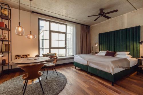汉堡汉堡伽斯特维克酒店的一间卧室配有一张大床和一张桌子及椅子