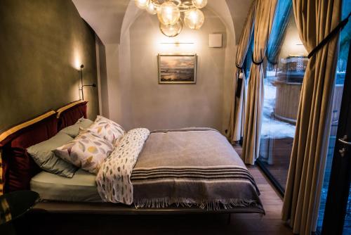 哈普萨卢Silma Retreat的一间卧室设有一张床、一个窗户和一个吊灯。