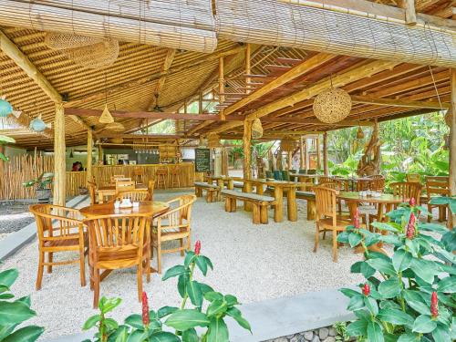 艾湄湾阿迪别墅酒店的餐厅设有木桌和木椅