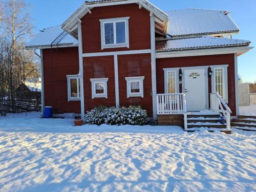 Röda villan的前面有雪的红色房子