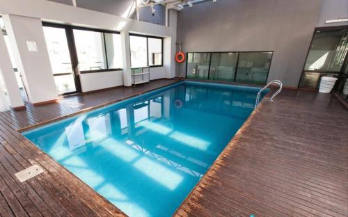 布宜诺斯艾利斯Buenos Aires Apartamento的大楼内一个蓝色的大型游泳池