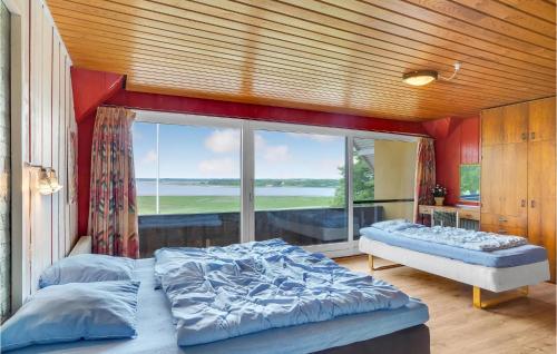 Hjarbæk瑞舒吉度假屋的一间卧室设有两张床和大窗户