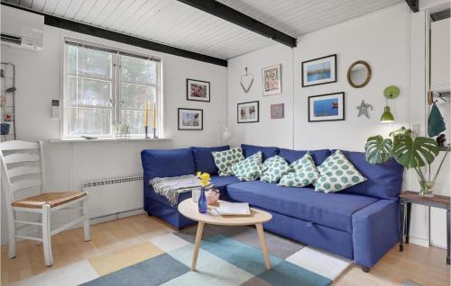 维斯特索马肯Stunning Home In Aakirkeby With Wifi的客厅配有一张蓝色的沙发,配有一张桌子
