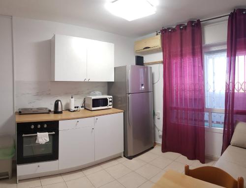 LodCozy Flat with Parking well-placed near TLV Airport的厨房配有冰箱和微波炉。