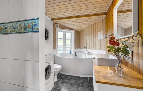 凡岛Nice Home In Fan With Wifi的带浴缸水槽和洗衣机的浴室