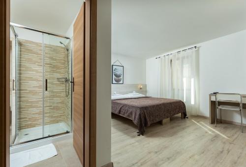 莫托文博尔戈别墅住宿加早餐旅馆的一间卧室设有一张床和一个玻璃淋浴间