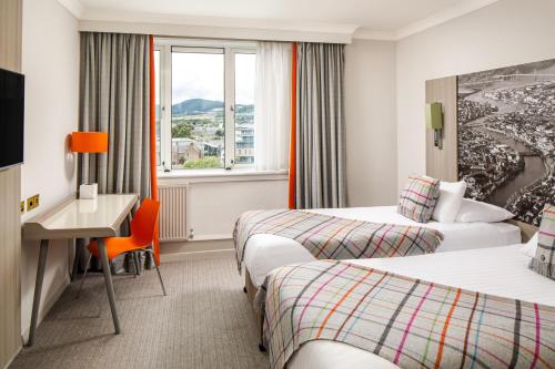 因弗内斯因弗内斯美居酒店的酒店客房设有两张床、一张书桌和一个窗户。