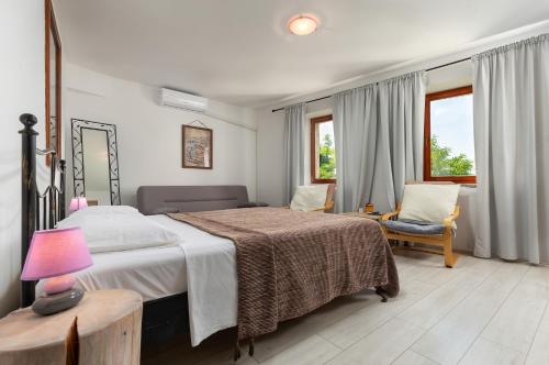 莫托文博尔戈别墅住宿加早餐旅馆的一间卧室配有一张床、一把椅子和窗户。