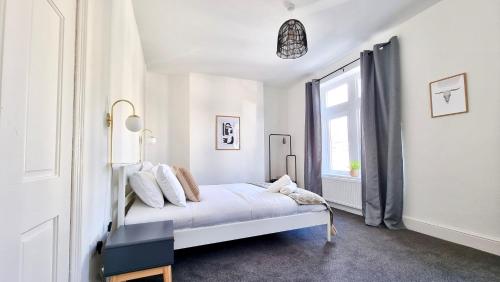 卡迪夫Moorland House by Switchback Stays的白色的卧室设有床和窗户