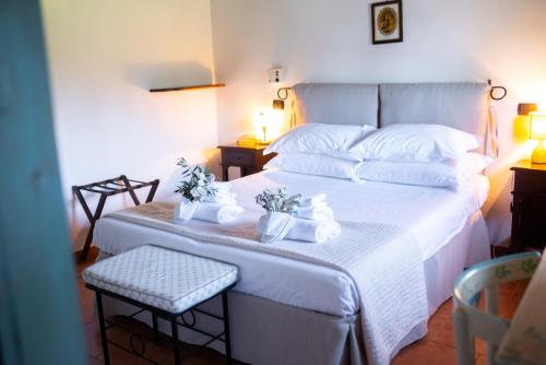 孔韦尔萨诺Masseria Montepaolo Dimora di Charme的卧室配有白色床,上面有两株植物