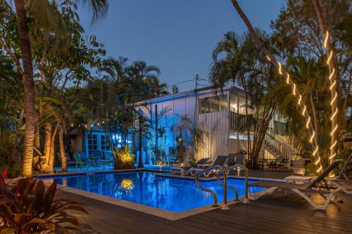 基韦斯特Papa's Hideaway的一座带游泳池和棕榈树的房子